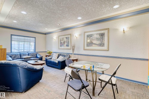 Community room featuring recessed lighting, wall sconces, textured ceiling, and patterned carpeting - #224 16303 95 St Nw, Edmonton, AB - Indoor