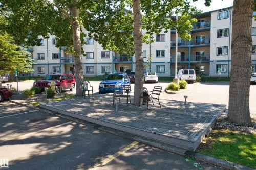 Multi-story residential building with light-colored exterior and contrasting blue trim - #224 16303 95 St Nw, Edmonton, AB - Outdoor With Balcony With Facade