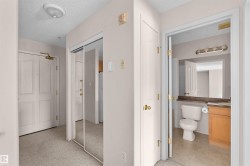 Entryway featuring textured carpeting and a mirrored closet door - 