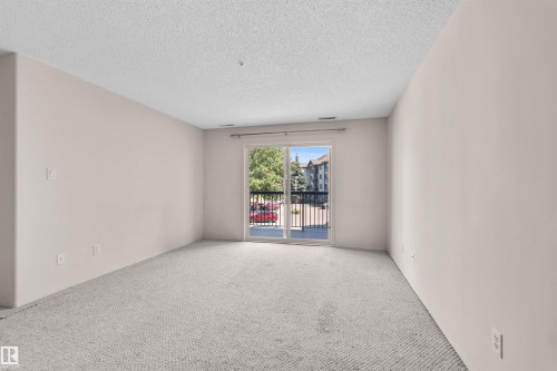 Neutral-toned walls complement the light-colored carpet, creating a bright interior - #224 16303 95 St Nw, Edmonton, AB - Indoor