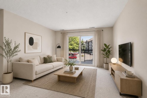 Living area featuring light-toned walls, plush carpet flooring, and a sliding glass door opening to a private balcony - #224 16303 95 St Nw, Edmonton, AB - Indoor Photo Showing Living Room