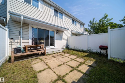 Private fenced patio featuring a sliding glass door entry, concrete paver area, and perimeter fencing - 11432 139 Avenue Nw, Edmonton, AB - Outdoor With Exterior