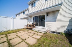 Rear exterior featuring light-colored horizontal siding and a sliding glass door - 