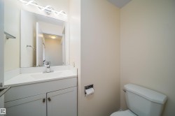 Contemporary vanity featuring a white countertop with integrated sink, chrome faucet, and a wall-mounted mirror - 