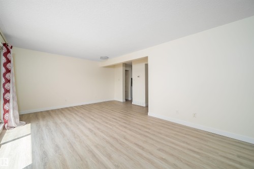 Spacious living area featuring light wood-finish flooring and neutral-toned walls - 11432 139 Avenue Nw, Edmonton, AB - Indoor Photo Showing Other Room