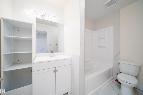 Bathroom featuring a white vanity with countertop, undermount sink, and chrome faucet - 11432 139 Avenue Nw, Edmonton, AB - Indoor Photo Showing Bathroom