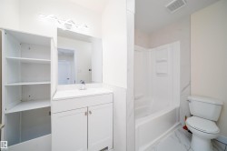 Bathroom featuring a white vanity with countertop, undermount sink, and chrome faucet - 