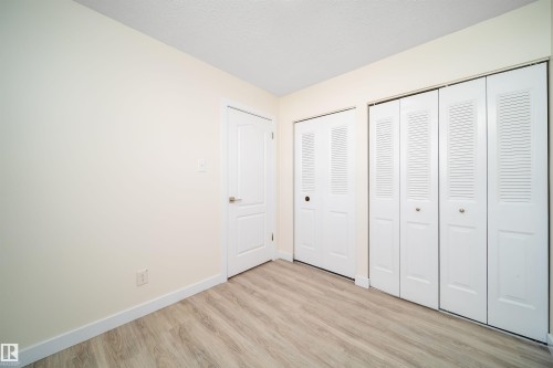 Light wood-finish flooring complements the neutral wall color - 11432 139 Avenue Nw, Edmonton, AB - Indoor Photo Showing Other Room