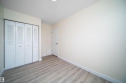 Interior room featuring wood-finish flooring, white baseboards, and light-toned walls - 