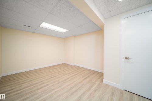 Expansive room featuring wood-finish flooring, white baseboards, and neutral wall paint - 11432 139 Avenue Nw, Edmonton, AB - Indoor Photo Showing Other Room