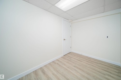 Room featuring wood-finish flooring, white baseboards, and a dropped ceiling with integrated lighting - 11432 139 Avenue Nw, Edmonton, AB - Indoor Photo Showing Other Room