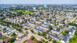 Aerial perspective showcasing a residential community with townhome-style residences and single-story homes - 