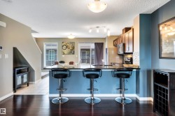 Open concept kitchen featuring a breakfast bar with a dark countertop and blue base - 