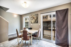 Dining area featuring tiled flooring, a sliding glass patio door, and a built-in wall sconce - 