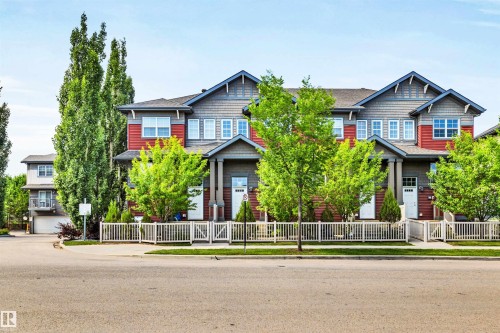 Townhome row featuring red and gray siding, multiple gables, and white framed windows - 571 Orchards Boulevard Sw, Edmonton, AB - Outdoor With Facade