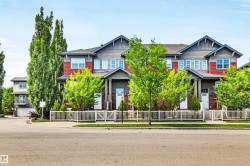 Townhome row featuring red and gray siding, multiple gables, and white framed windows - 