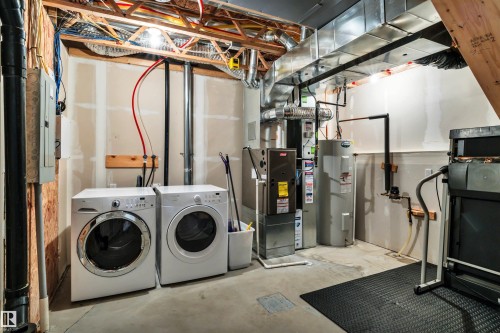 Utility area featuring a water heater, furnace, and washer/dryer - 571 Orchards Boulevard Sw, Edmonton, AB - Indoor Photo Showing Laundry Room