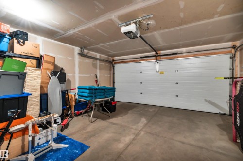 Double attached vehicle garage featuring a paneled overhead door with an automatic opener - 571 Orchards Boulevard Sw, Edmonton, AB - Indoor Photo Showing Garage