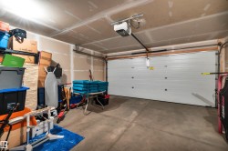 Double attached vehicle garage featuring a paneled overhead door with an automatic opener - 