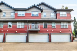 Townhome exterior featuring horizontal red siding and gray shingle accents - 