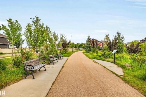Outdoor pathway featuring a gravel surface bordered by a concrete sidewalk - 571 Orchards Boulevard Sw, Edmonton, AB - Outdoor