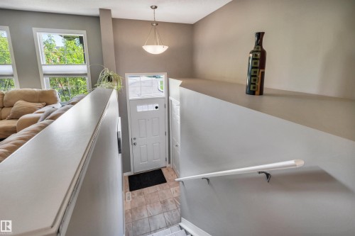 Entryway featuring a white paneled door with glass inserts and transom window - 571 Orchards Boulevard Sw, Edmonton, AB - Indoor Photo Showing Other Room