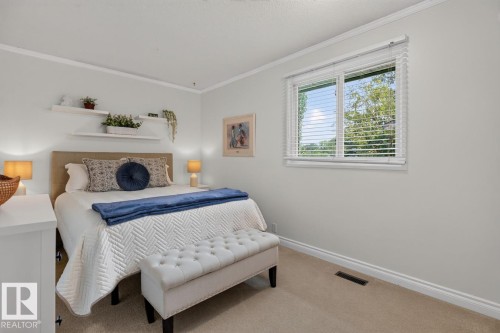 Carpeted bedroom with a window featuring white blinds, crown molding, and baseboards - 27 Milford Crescent, Sherwood Park, AB - Indoor Photo Showing Bedroom