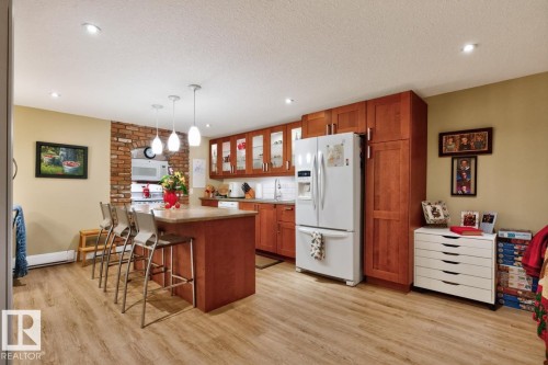 Spacious kitchen featuring wood-finish flooring, extensive wood cabinetry, and recessed lighting - 27 Milford Crescent, Sherwood Park, AB - Indoor Photo Showing Kitchen