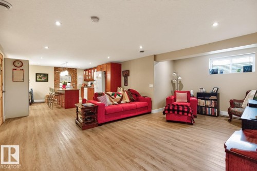 Open-concept living space featuring wood-finish flooring, recessed lighting, and neutral wall tones - 27 Milford Crescent, Sherwood Park, AB - Indoor