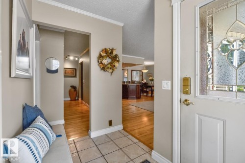 Entryway featuring a decorative leaded glass door, neutral wall tones, and crown molding - 27 Milford Crescent, Sherwood Park, AB - Indoor Photo Showing Other Room
