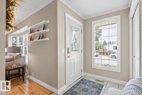 Entryway featuring a decorative glass paneled door, large side window with blinds, and light tile flooring - 27 Milford Crescent, Sherwood Park, AB - Indoor Photo Showing Other Room