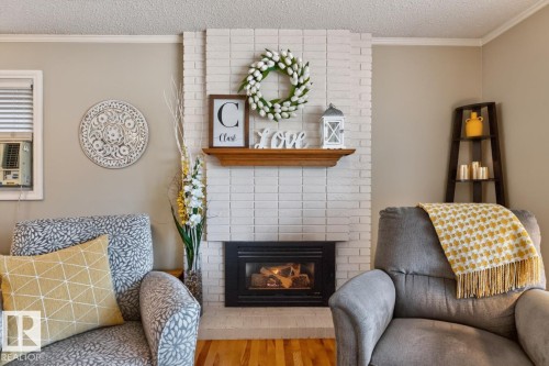 Elegant living room anchored by a white subway tile fireplace with black insert and wooden mantel display - 27 Milford Crescent, Sherwood Park, AB - Indoor Photo Showing Living Room With Fireplace