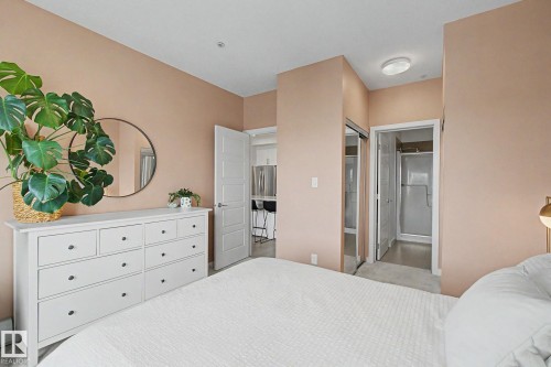Bedroom featuring soft pink walls and light-toned carpet flooring - #435 1008 Rosenthal Bv Nw, Edmonton, AB - Indoor Photo Showing Bedroom