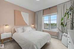 Bedroom featuring a large multi-pane window, wall-to-wall carpeting, and light-toned walls - 