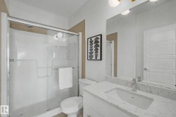 Contemporary bathroom featuring a white vanity with an integrated sink and light-colored countertop - 