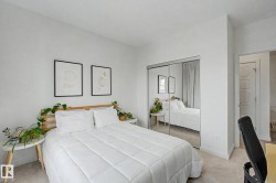 Bedroom featuring light-colored carpet, white walls, and a mirrored sliding closet door - 