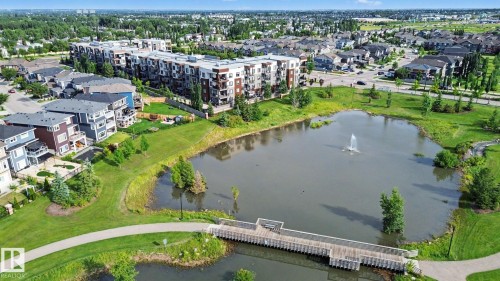Expansive parkland with a pond featuring a decorative fountain - #435 1008 Rosenthal Bv Nw, Edmonton, AB - Outdoor With Body Of Water With View