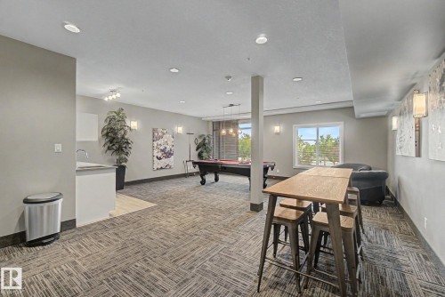 Recreational room featuring patterned carpet flooring, recessed lighting, and expansive windows - #435 1008 Rosenthal Bv Nw, Edmonton, AB - Indoor