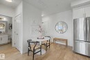 Entry area featuring wood-finish flooring, white paneled doors, and contemporary lighting - #435 1008 Rosenthal Bv Nw, Edmonton, AB  - Indoor 