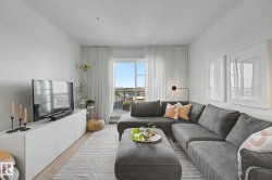 Living area featuring light wood-finish flooring and a white media console - 