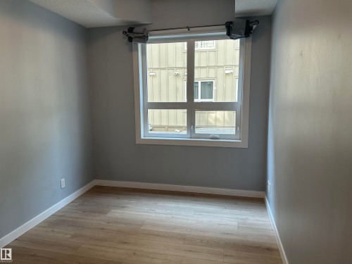 Interior space featuring light-toned walls, wood-finish flooring, and white baseboards - #203 11103 84 Av Nw, Edmonton, AB - Indoor Photo Showing Other Room