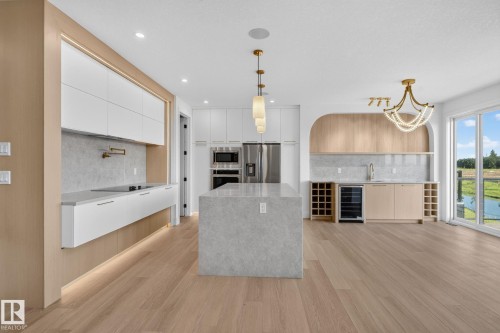 Open-concept kitchen and entertaining space featuring light wood-finish flooring - 8791 Mayday Ln Sw Sw, Edmonton, AB - Indoor Photo Showing Kitchen With Upgraded Kitchen