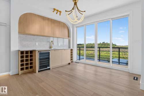 Integrated wet bar featuring a built-in wine cooler, wine rack storage, and a gold-finish faucet - 8791 Mayday Ln Sw Sw, Edmonton, AB - Indoor