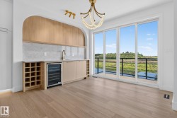 Integrated wet bar featuring a built-in wine cooler, wine rack storage, and a gold-finish faucet - 