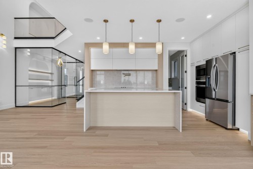 Open-concept living area featuring light wood-finish flooring - 8791 Mayday Ln Sw Sw, Edmonton, AB - Indoor Photo Showing Kitchen With Upgraded Kitchen