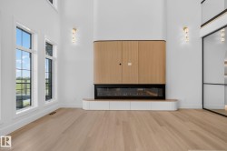 Great room featuring a built-in media center with wood-finish cabinetry, an electric linear fireplace, and integrated lower storage - 