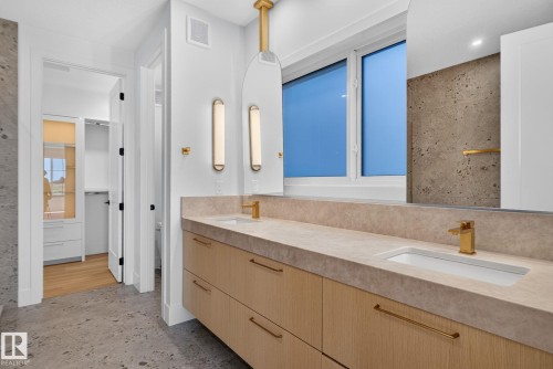 Dual vanity with integrated sinks, light wood-finish cabinetry, and gold-tone fixtures - 8791 Mayday Ln Sw Sw, Edmonton, AB - Indoor Photo Showing Bathroom