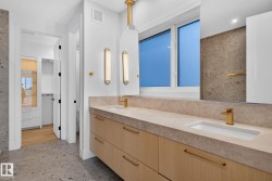 Dual vanity with integrated sinks, light wood-finish cabinetry, and gold-tone fixtures - 