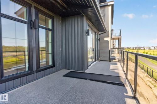 Private balcony featuring a glass railing system and a textured concrete surface - 8791 Mayday Ln Sw Sw, Edmonton, AB - Outdoor With Exterior