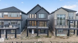 Modern multi-level residence featuring dark gray siding and a prominent gabled roofline - 